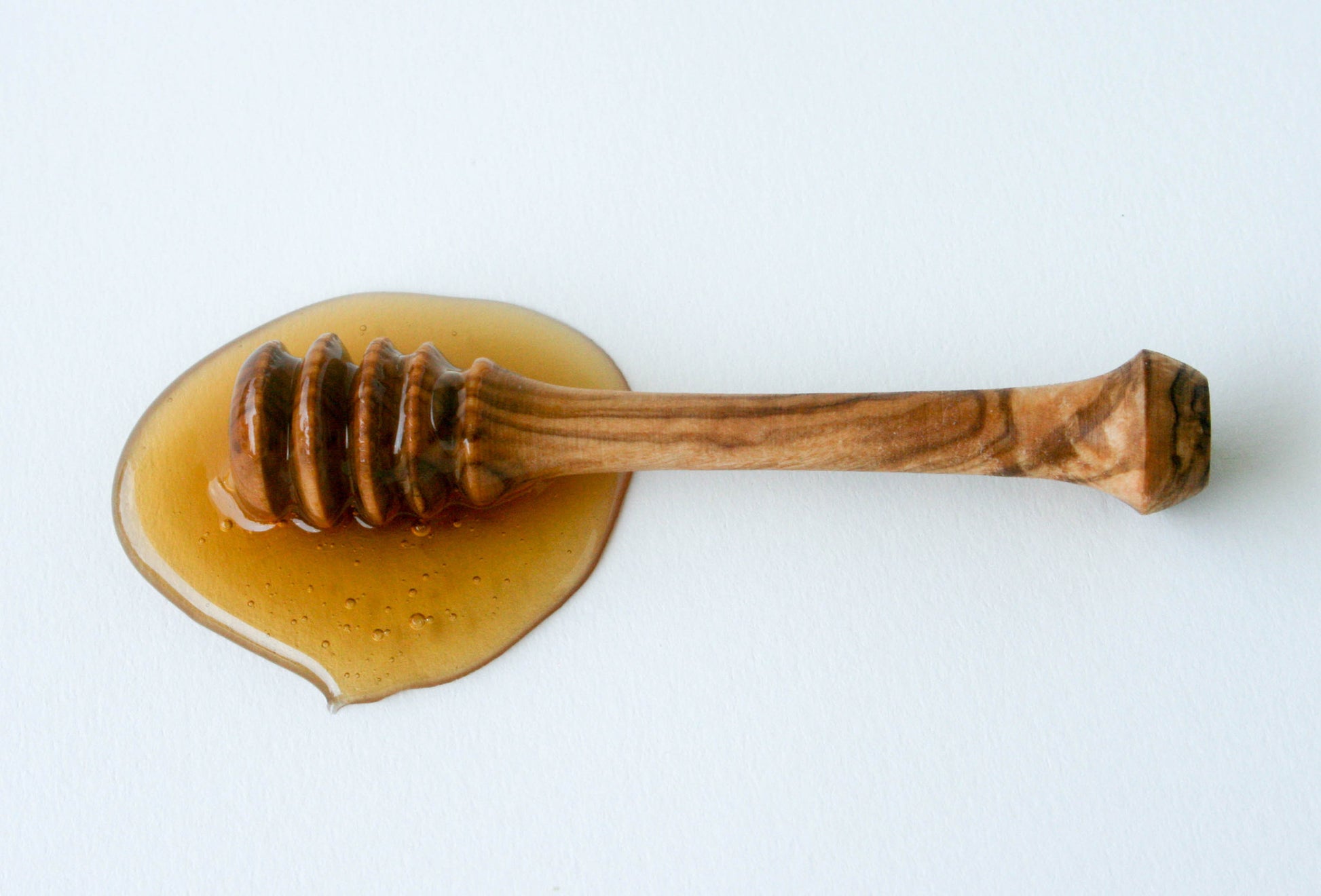 Olive wood honey dipper resting in golden honey – sustainable, handcrafted kitchen tool perfect for drizzling raw honey with style and precision.