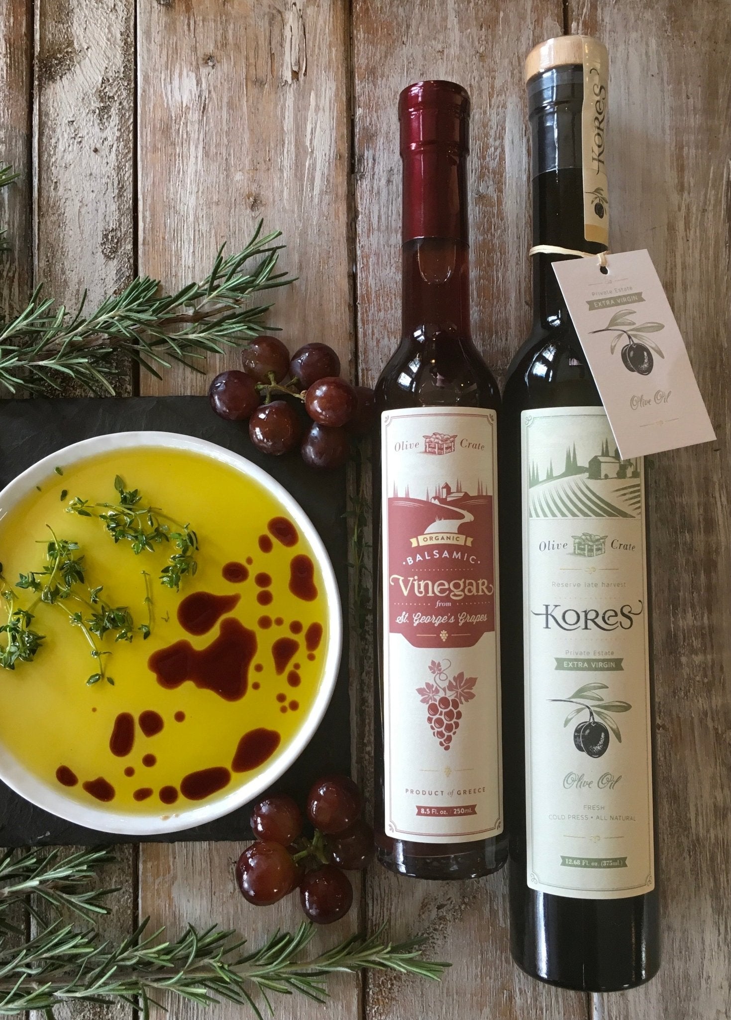 Kores Estate Manaki EVOO and St. George's Agiorgitiko balsamic vinegar on rustic wood with fresh dill and dipping dish, Greece