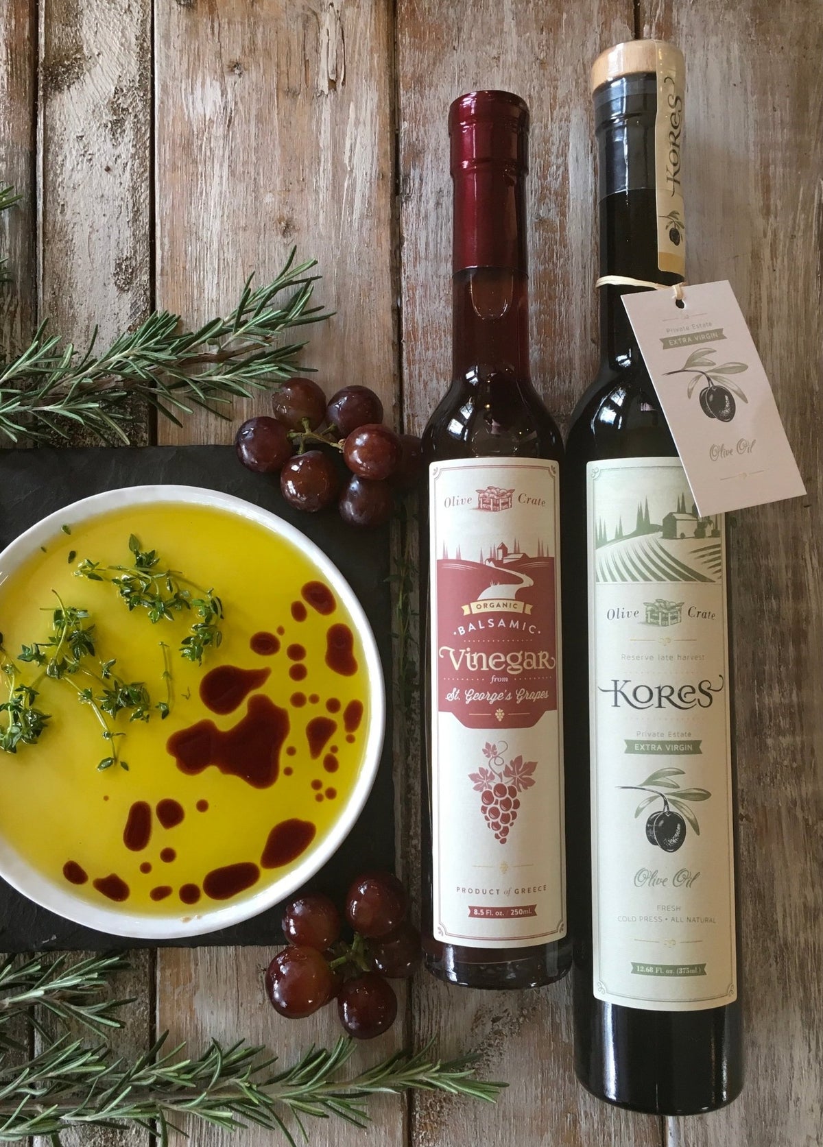 Kores Estate Manaki EVOO and St. George's Agiorgitiko balsamic vinegar on rustic wood with fresh dill and dipping dish, Greece
