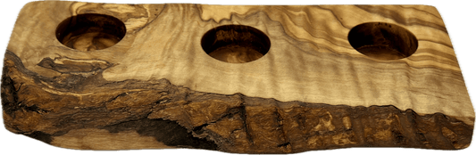 Alt text (updated): Hand-carved olive wood three votive candle holder with dramatic natural bark edge, three equally spaced candle wells, approximately 9 to 10 inches long